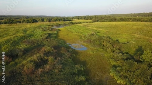 Aerial View. Flying over the beautiful sunny field with river