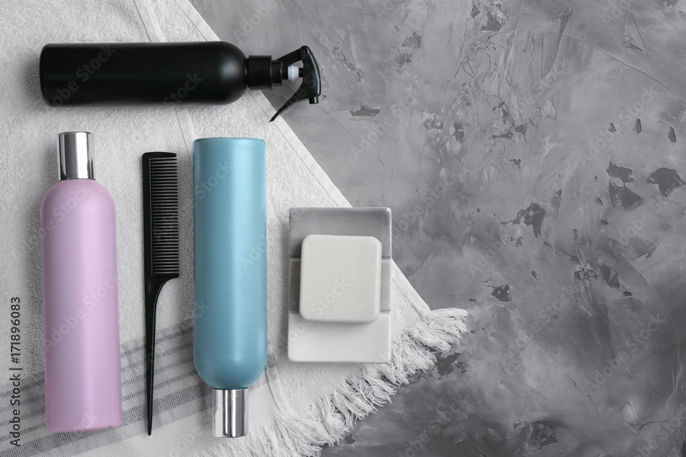 Beautiful composition with cosmetics, comb and bath towel on gray background Beautiful composition with cosmetics, comb and bath towel on gray background