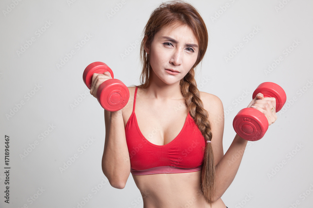 Tired Asian healthy girl exercise with dumbbell. Tired Asian healthy girl exercise with dumbbell.