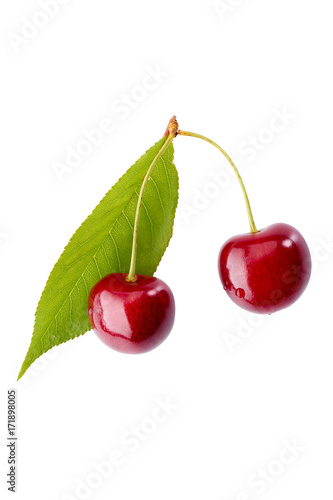 Two ripe cherries with leaf on white