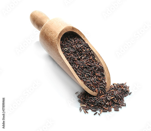 Wooden scoop with black rice on white background