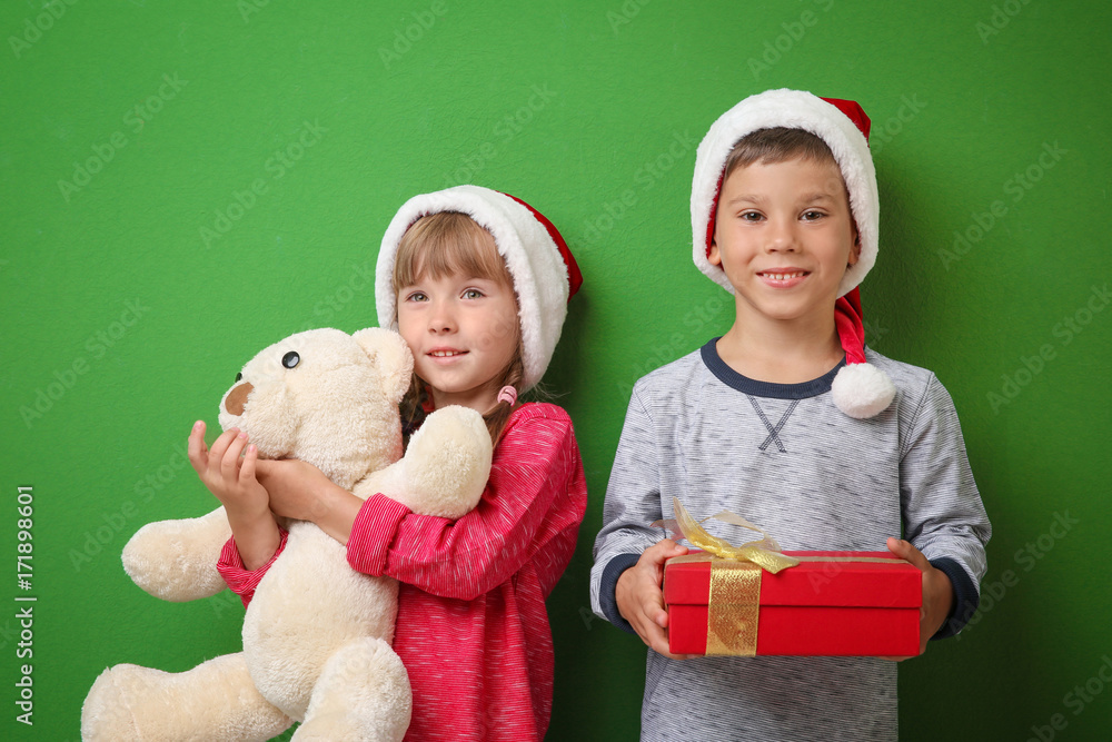 Cute little children with Christmas presents on color background Cute little children with Christmas presents on color background
