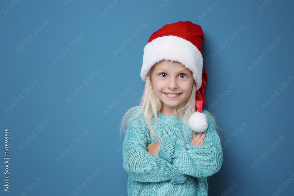 Cute girl in Santa hat on color background Cute girl in Santa hat on color background