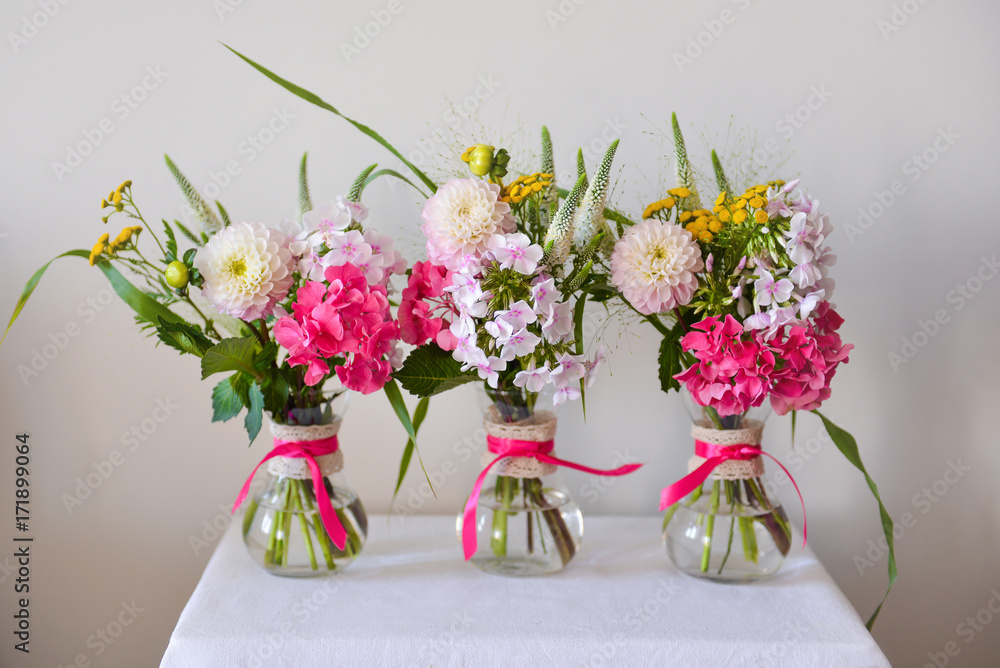 three vases with flowers with small bouquets