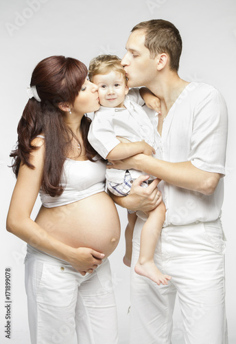 Happy Family Kiss Child, Pregnant Mother Father Kissing Kid Boy, Young Parents and Baby two years old