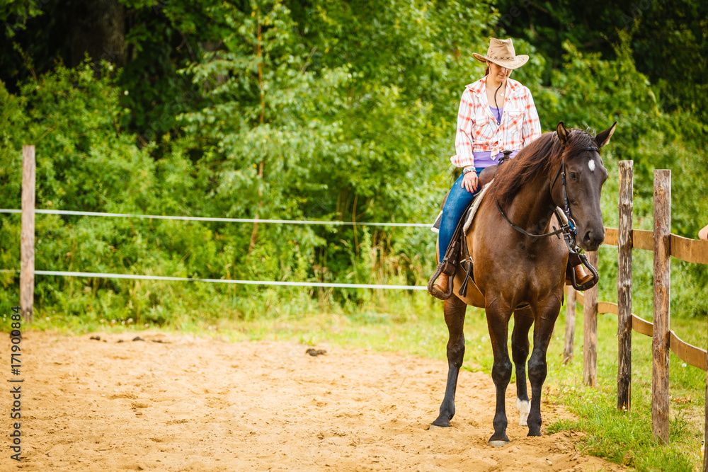 Cowgirl doing horse riding on countryside meadow Cowgirl doing horse riding on countryside meadow