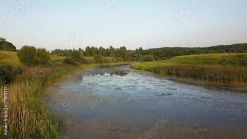 Aerial View. Flying over the beautiful sunny field with river
