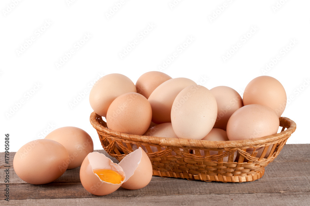 eggs on a wooden table in a wicker basket on a white background eggs on a wooden table in a wicker basket on a white background