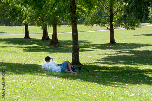 Cyclist resting in the park on the grass.
