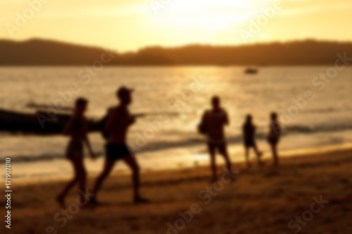 Blurred background of silhouette couple on beach when sunset tine