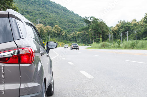 Car parked inside road with mountain and car running in back © JC_STOCKER
