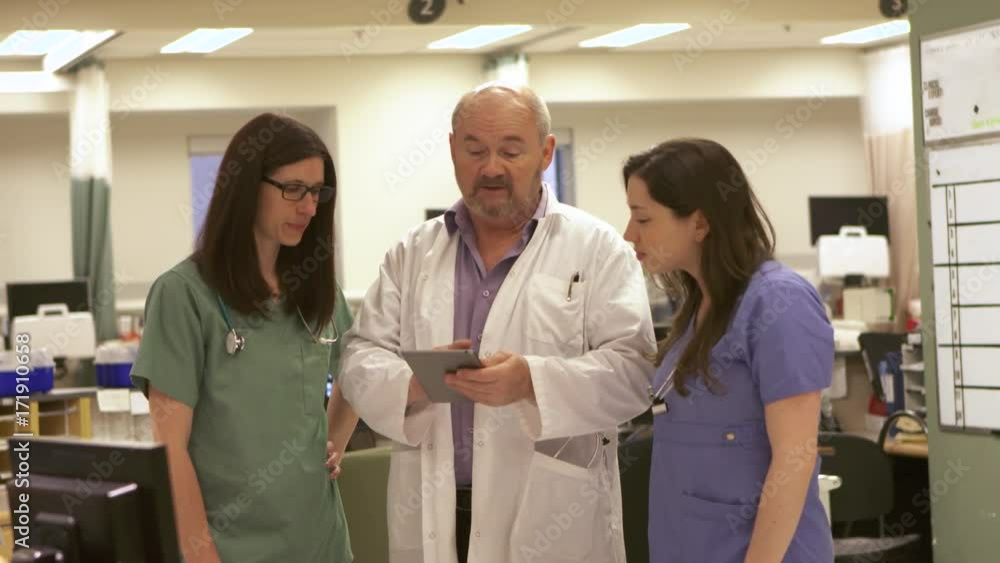 Doctor and Nurses review data on a tablet computer. Doctor and Nurses review data on a tablet computer.