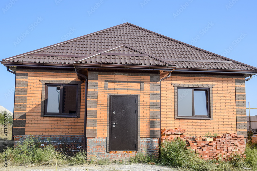 The house with plastic windows and a roof of corrugated sheet The house with plastic windows and a roof of corrugated sheet