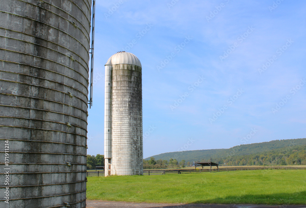 View of a silo in the distance with a portion of a silo to the left side
