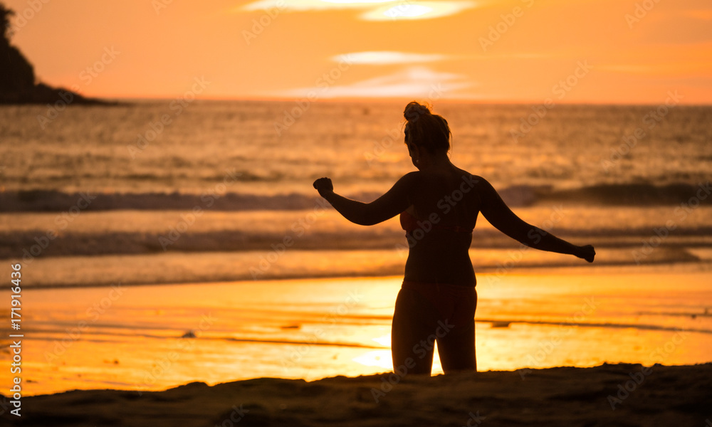 Fototapeta premium Silhouette Women are doing activities on the beach with sunset.