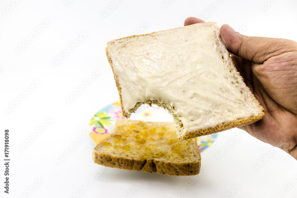 The bite slide bread with mayonnaise in the man hand