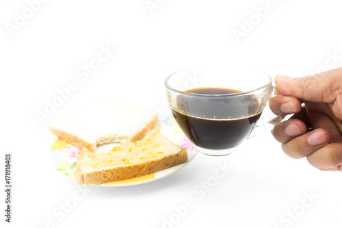 Man hand is holding  a black coffee cup with the bited of slide bread on the dish