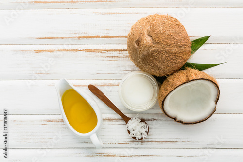 Coconut with coconut oil on white wooden table background. Good for package design element