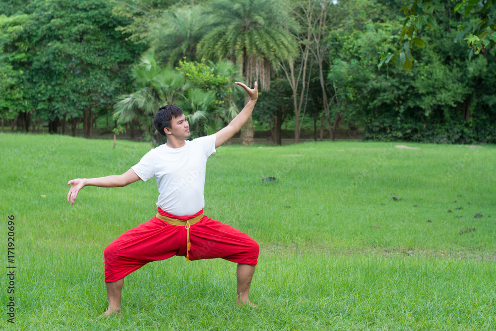 Asian young boy Thai dance. Classical Dance in white shirt red loincloth, Demonstrate dance in the garden. Asian young boy Thai dance. Classical Dance in white shirt red loincloth, Demonstrate dance in the garden.