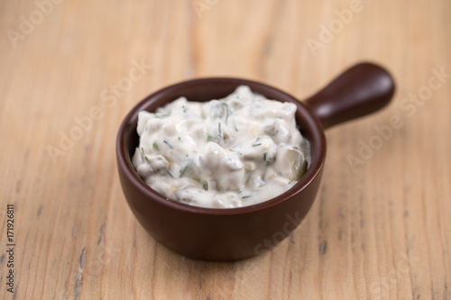 tartar sauce in a gravy boat on a wooden surface