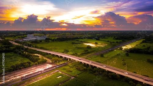 Aerial Photo Countryside Road Bridge Over Railway The train is running through the bridge and Golden Hour Sky Beautiful Landscape Drone View