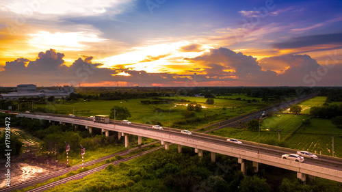 Aerial Photo Countryside Car Running on Road Bridge Over Railway and Golden Hour Sky Beautiful Landscape Drone View