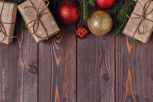Christmas gift boxes and fir tree  on wooden background.