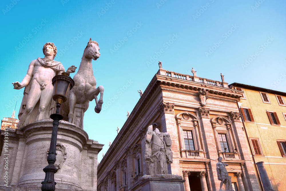 Fototapeta premium Marble statues of the Dioscuri, Castor and Pollux, at the top of the staircase, with Capitol Square or Piazza del Campidoglio in background. Rome, Italy.