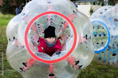 Little girl fun plays bumperball outdoors