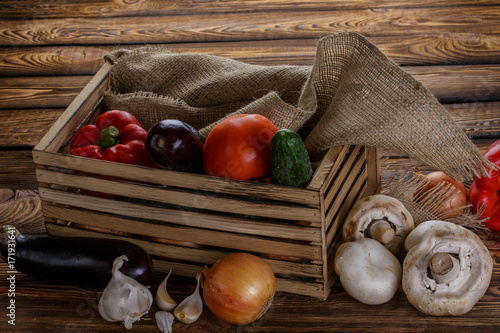 Fresh vegetables in wooden box on wooden background photo