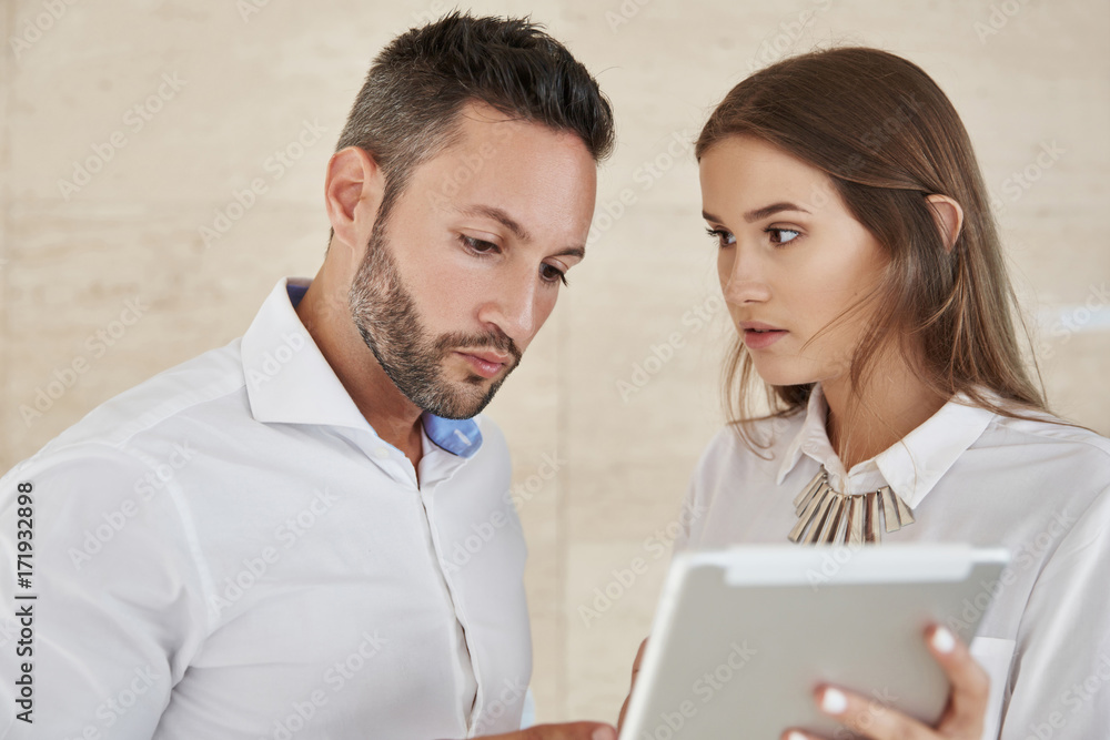 Pretty businesswoman working with coworker on tablet Pretty businesswoman working with coworker on tablet