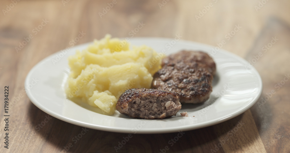 mashed potatoes with cutlets on white plate