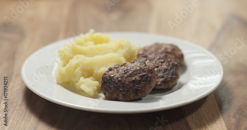 mashed potatoes with cutlets on white plate