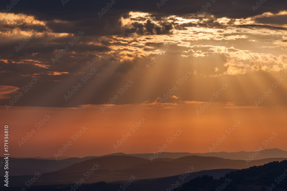 Sky with beautiful clouds and sunbeams at sunset