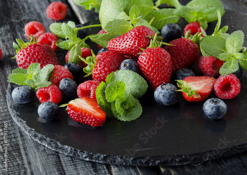 fresh strawberries  raspberries and blueberries on a black background