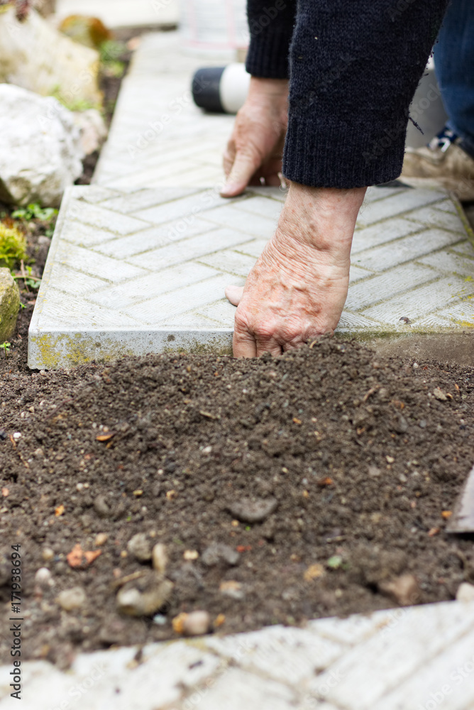 Repair of the tile pavement. Installation of paving slabs. Man puts concrete tiles into the ground. Repair of the tile pavement. Installation of paving slabs. Man puts concrete tiles into the ground.