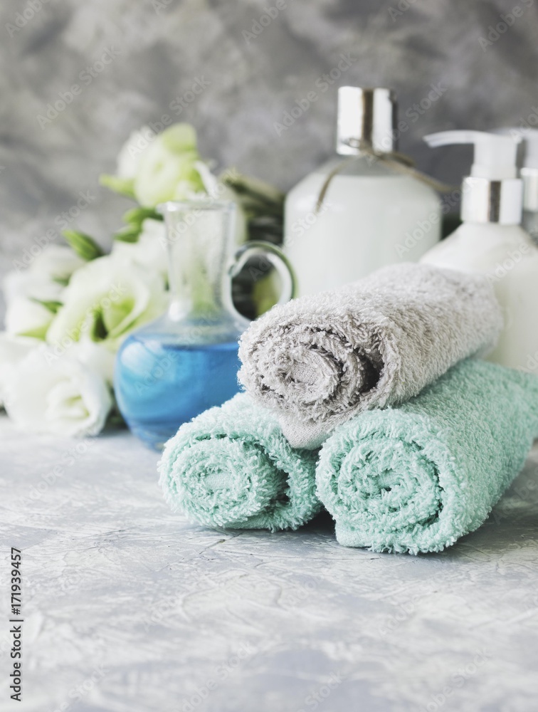 Spa set on a white marble table with a stack of towels, selective focus Spa set on a white marble table with a stack of towels, selective focus
