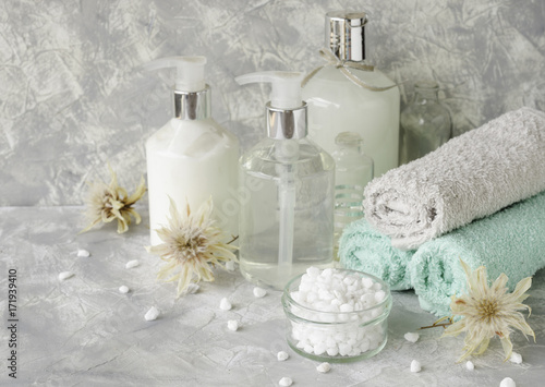 Spa set on a white marble table with a stack of towels  selective focus