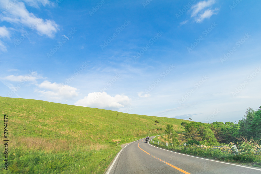 Beautiful  landscape view of  a country road and green grass with  blue sky  background of Utsukushigahara park is  one of the most important and popular natural place in Nagano Prefecture , Japan.