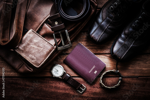 Men's leather accessories and passport on rustic wooden board background, flat lay fashion and beauty, travel concept