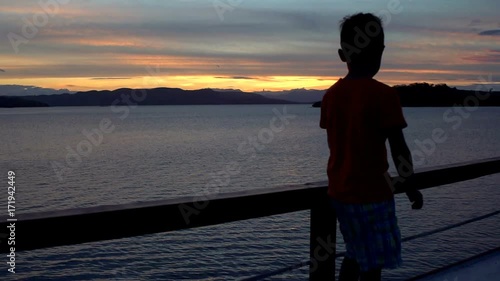 Silhouette of sailing boy into the sunset, steadycam, slomotion
