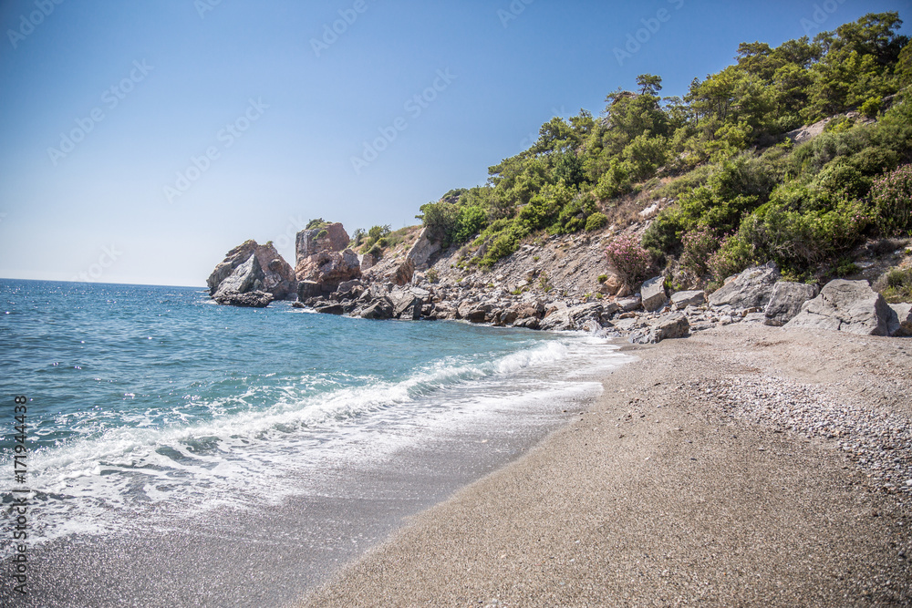 wild beach, sand and green rocks