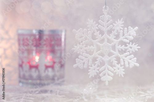 Christmas and a snowflake. Christmas candle with deer ornament and snowflakes. Selective focus. photo