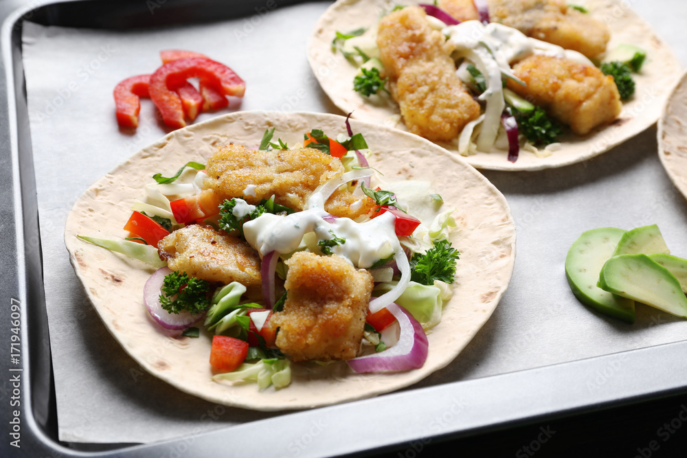 Tasty fish tacos on baking tray Tasty fish tacos on baking tray