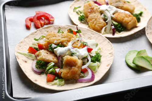 Tasty fish tacos on baking tray