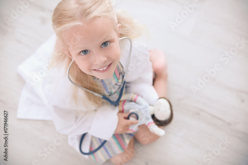 Little girl in medical coat...