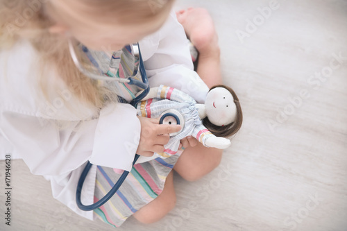 Little girl in medical coat...