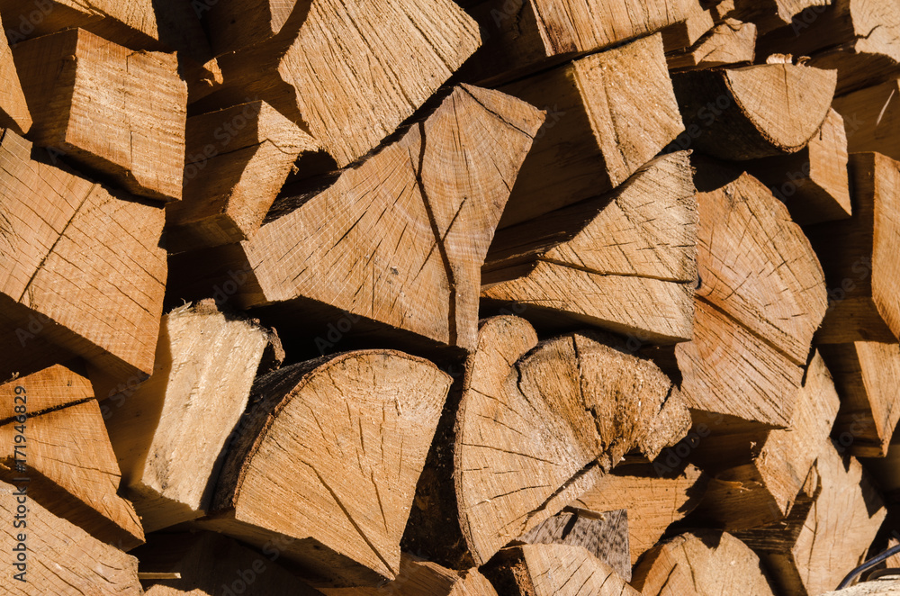 A pile of stacked firewood, prepared for heating the house. Firewood harvested for heating in winter. Chopped firewood on a stack. Firewood stacked and prepared for winter Pile of wood logs. A pile of stacked firewood, prepared for heating the house. Firewood harvested for heating in winter. Chopped firewood on a stack. Firewood stacked and prepared for winter Pile of wood logs.