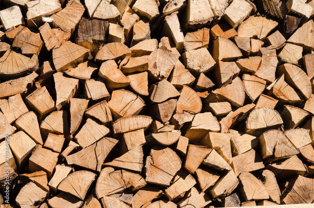 A pile of stacked firewood, prepared for heating the house. Firewood harvested for heating in winter. Chopped firewood on a stack. Firewood stacked and prepared for winter Pile of wood logs. A pile of stacked firewood, prepared for heating the house. Firewood harvested for heating in winter. Chopped firewood on a stack. Firewood stacked and prepared for winter Pile of wood logs.