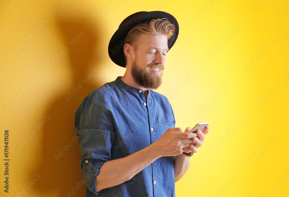 Young hipster man using smartphone on color background Young hipster man using smartphone on color background